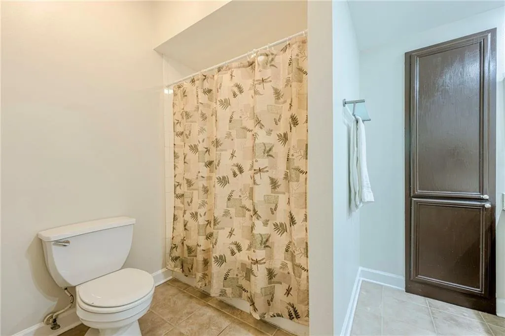 Primary bath featuring light tile patterned floors and a shower with curtain