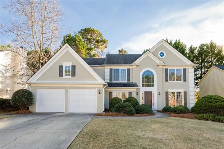 Stucco exterior with multiple gables and a circular window accent