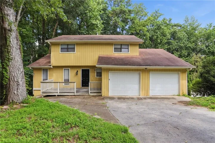 Two-story residence featuring a yellow siding exterior and a dark roof