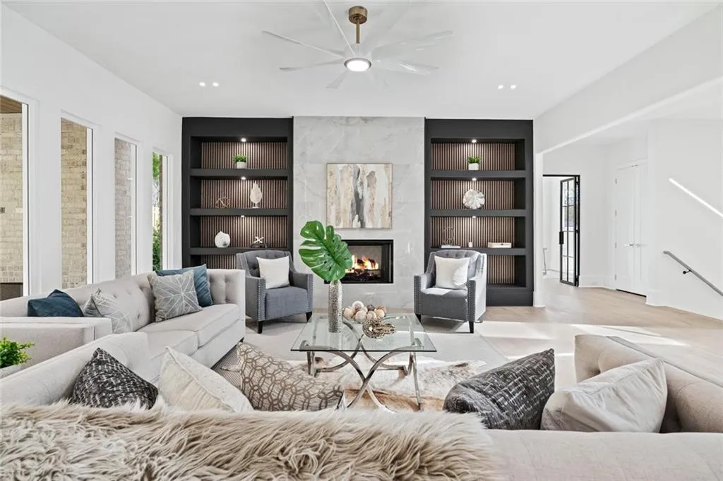 Living area with built in shelves, a ceiling fan, a premium fireplace, and recessed lighting