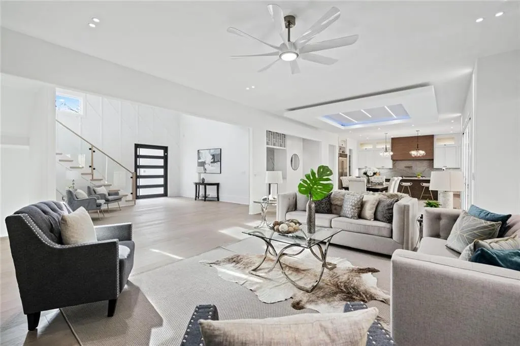 Living area with ceiling fan, stairway, wood finished floors, and recessed lighting