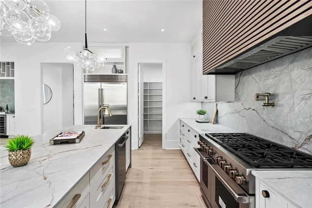 Kitchen featuring tasteful backsplash, light stone counters, white cabinets, and recessed lighting