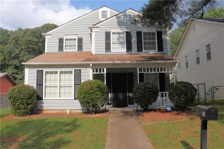 Two-story residential structure featuring light grey siding and black shutters