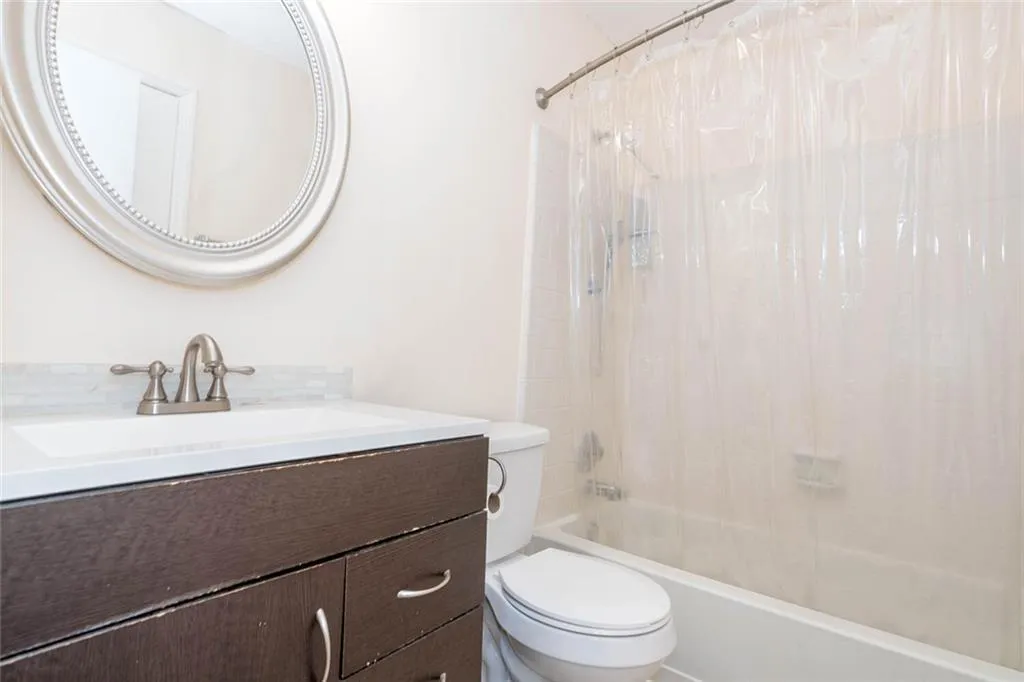 Full bathroom with vanity, toilet, and shower / bath combination with curtain