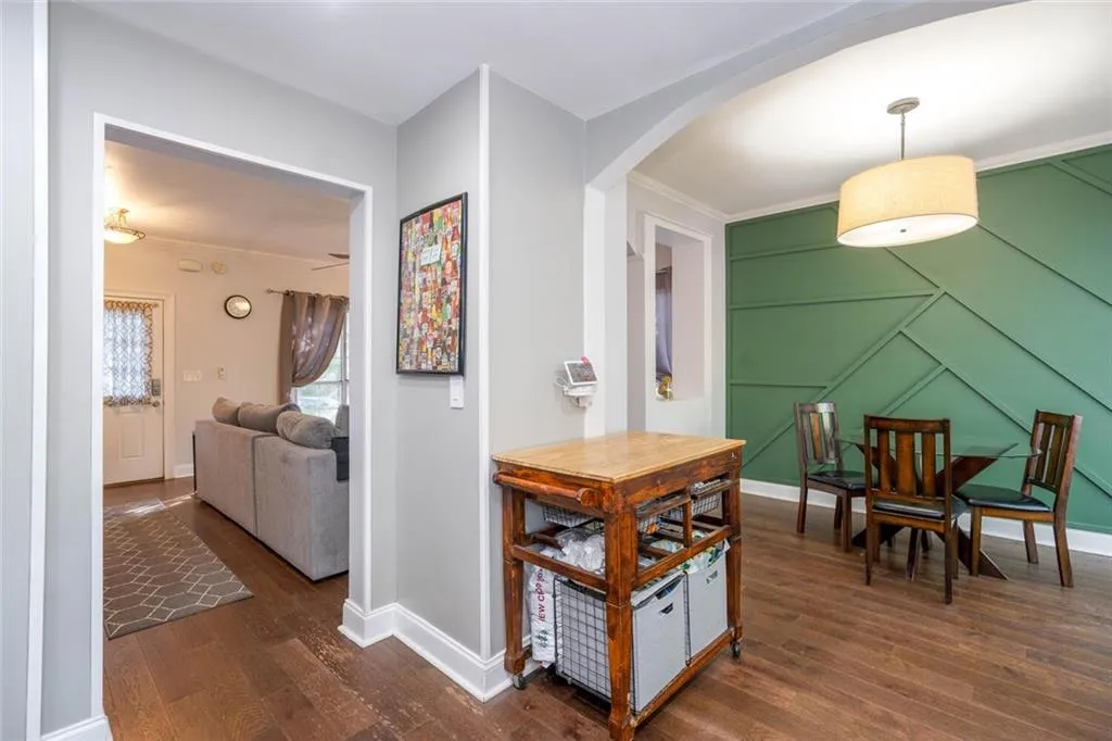 Hall with crown molding and dark wood-type flooring
