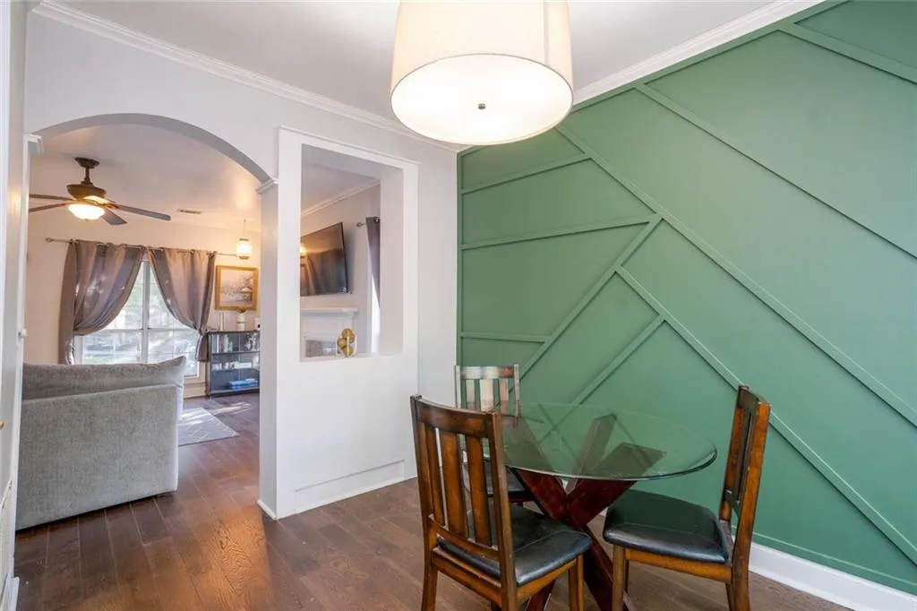 Dining space featuring ornamental molding, dark hardwood / wood-style flooring, and ceiling fan