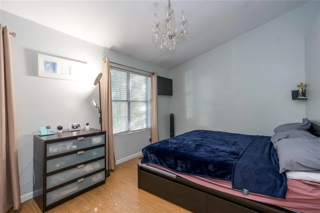 Bedroom with hardwood / wood-style flooring and a chandelier