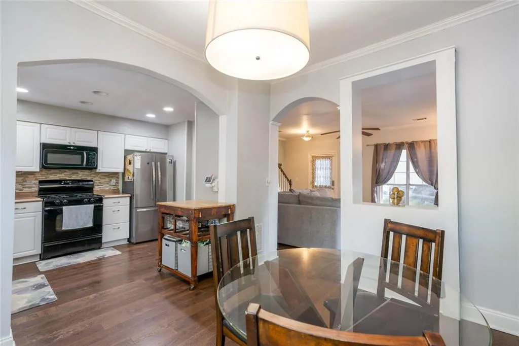 Dining room with ceiling fan, dark hardwood / wood-style floors, and ornamental molding
