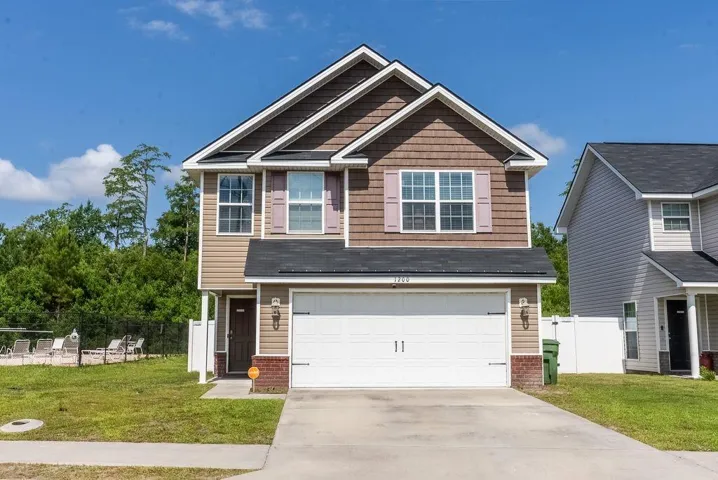 Craftsman-style house featuring concrete driveway, an attached garage, and brick siding