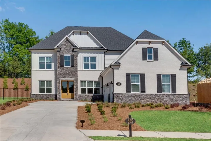 Craftsman inspired home with a garage and a front lawn