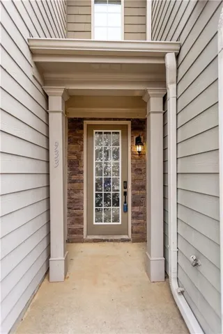 Property entrance featuring stone siding and a porch