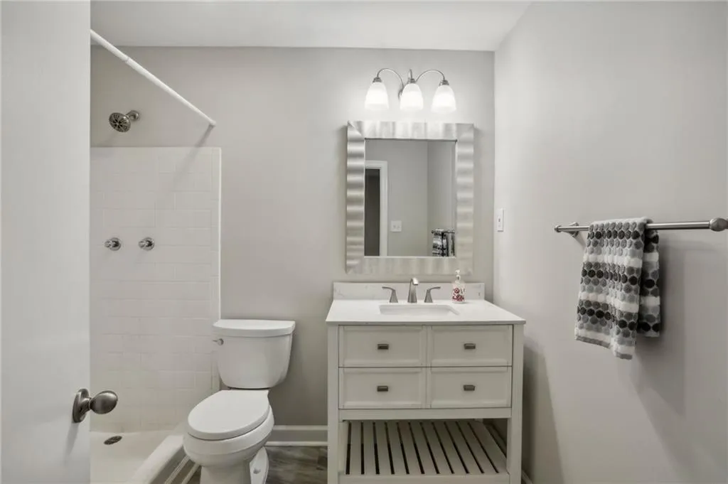 Full bathroom featuring tiled shower, vanity, and toilet on terrace level