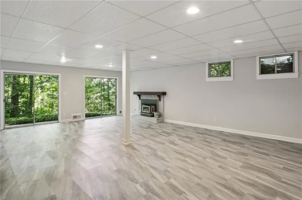 Terrace level great room/bonus room with woodburning stove with whitewash finish, sliding doors and LVP flooring.