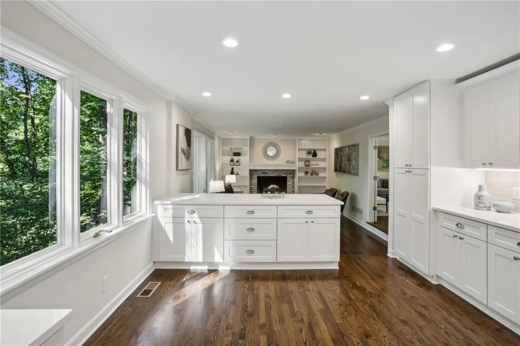 Kitchen featuring white cabinets, oak floors, plenty of natural light, and plenty of room for an eat-in seating area.