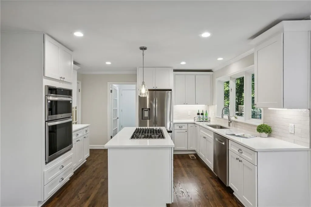 Kitchen with Quartz countertops and white shaker style soft close cabinets.