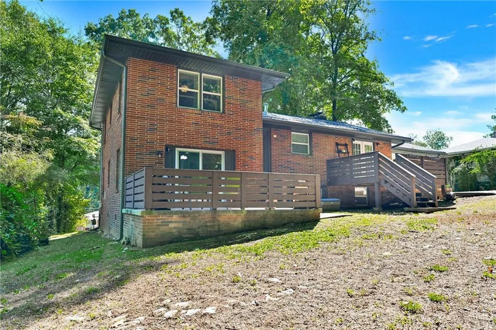 View of front facade featuring brick siding and a wooden deck