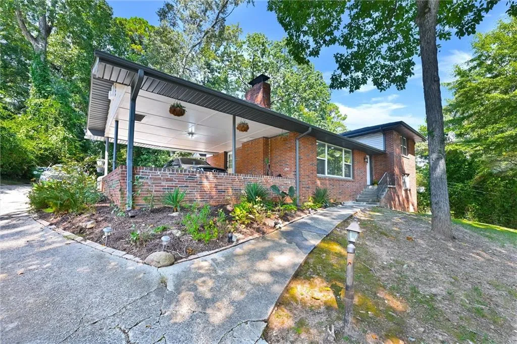 View of front of property featuring brick siding and a chimney