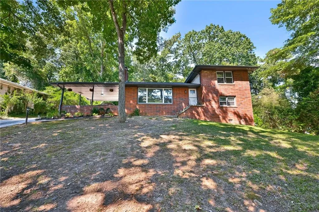 Tri-level home featuring crawl space, brick siding, and a front lawn
