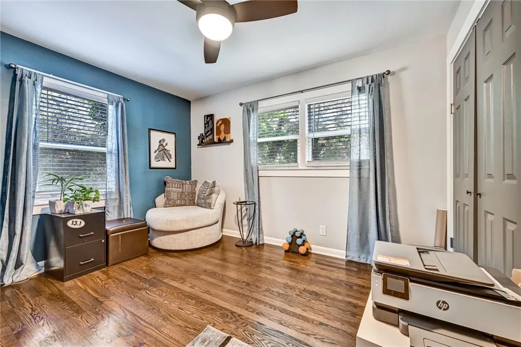 Living area featuring wood finished floors, a ceiling fan, and baseboards