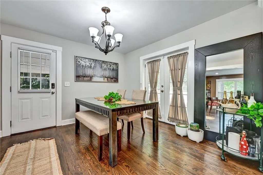 Dining room featuring a chandelier, french doors, wood finished floors, and baseboards
