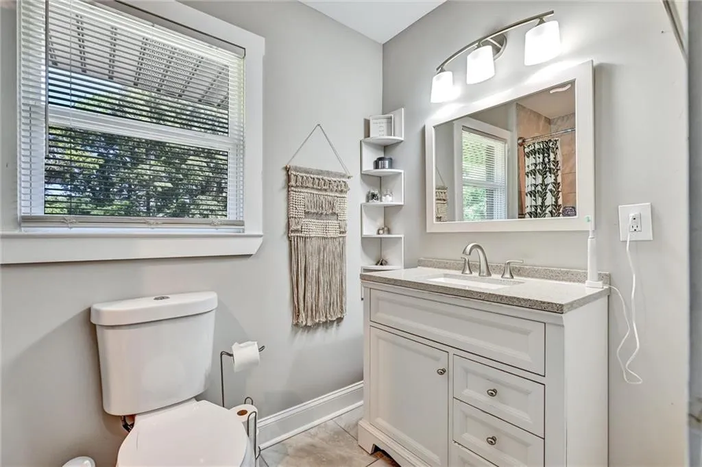 Full bathroom with a shower with curtain, baseboards, vanity, and toilet