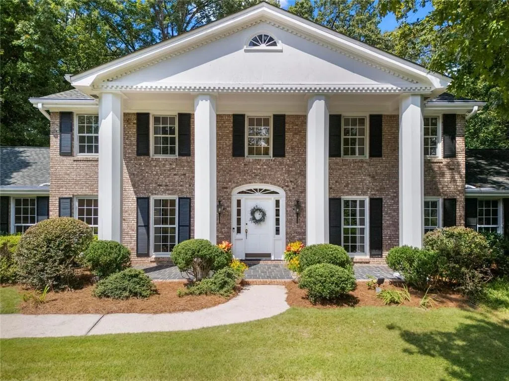 Classic brick traditional with grand columned entry, timeless architectural details, and beautifully landscaped curb appeal.