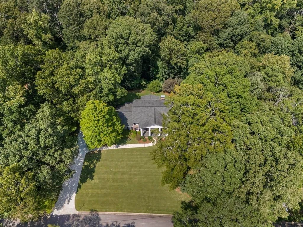 Aerial view of the property showcasing its private wooded setting.