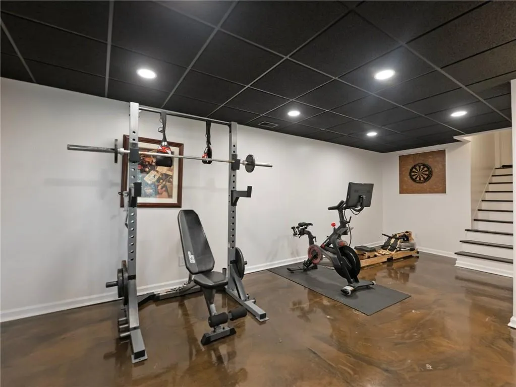 Exercise area with a drop ceiling and concrete flooring