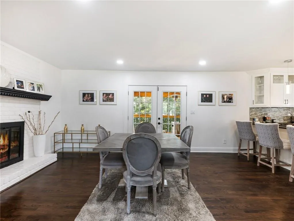 Dining space featuring french doors, dark wood-type flooring, and a brick fireplace