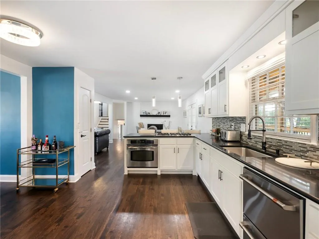 Kitchen featuring tasteful backsplash, sink, stainless steel appliances, and dark hardwood / wood-style floors