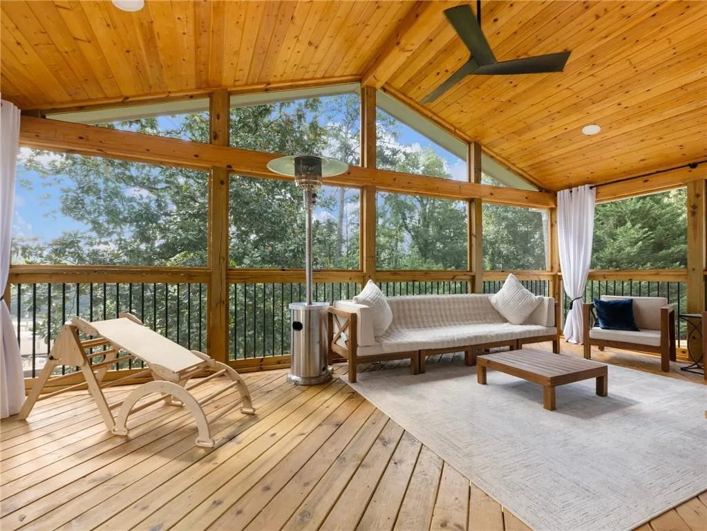 Sunroom / solarium featuring ceiling fan, a healthy amount of sunlight, vaulted ceiling with beams, and wood ceiling