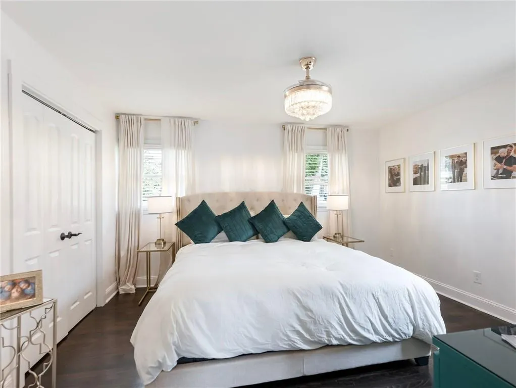Bedroom with dark hardwood / wood-style floors, a closet, and a chandelier