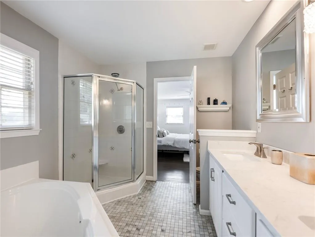 Bathroom featuring tile patterned floors, vanity, and a healthy amount of sunlight