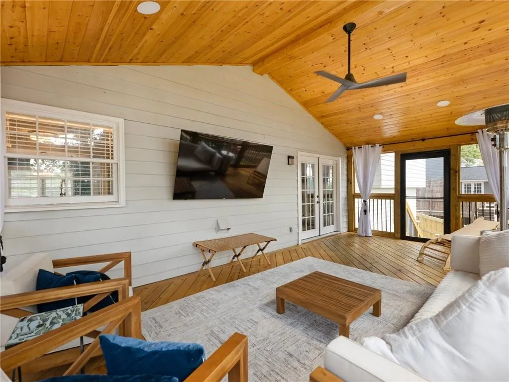 Living room featuring french doors, ceiling fan, wood-type flooring, lofted ceiling with beams, and wood ceiling