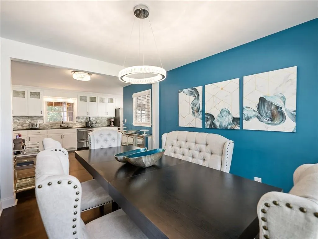 Dining space with sink and dark wood-type flooring