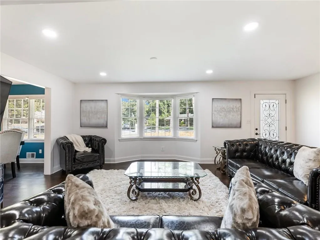 Living room featuring dark wood-type flooring and a healthy amount of sunlight