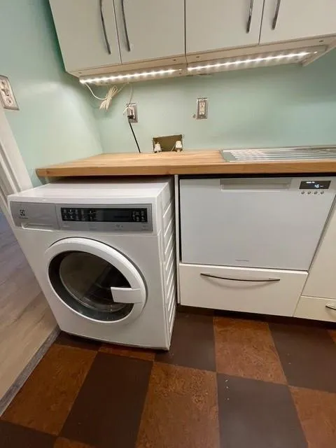Washroom featuring washer and cabinets