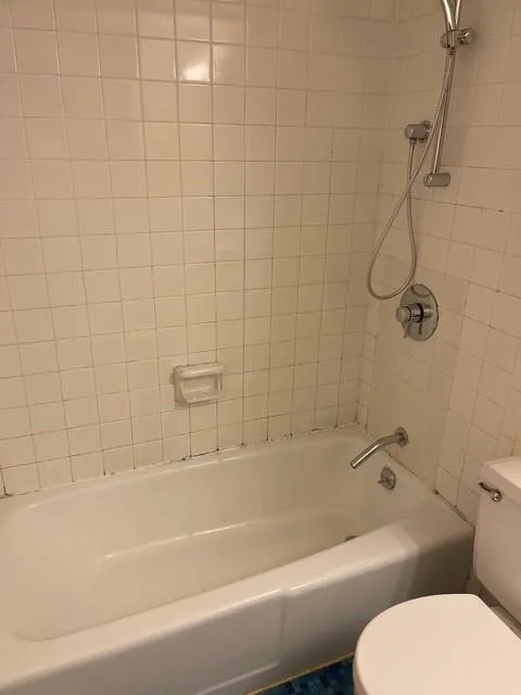 Bathroom featuring toilet and tiled shower / bath combo