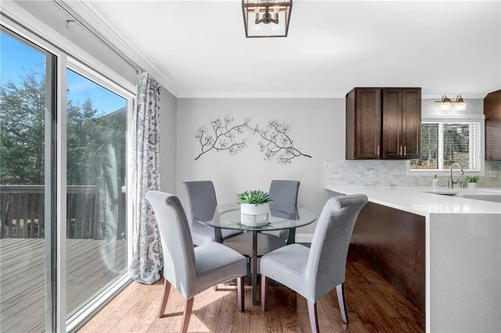 Dining space featuring sink, an inviting chandelier, hardwood / wood-style floors, and ornamental molding