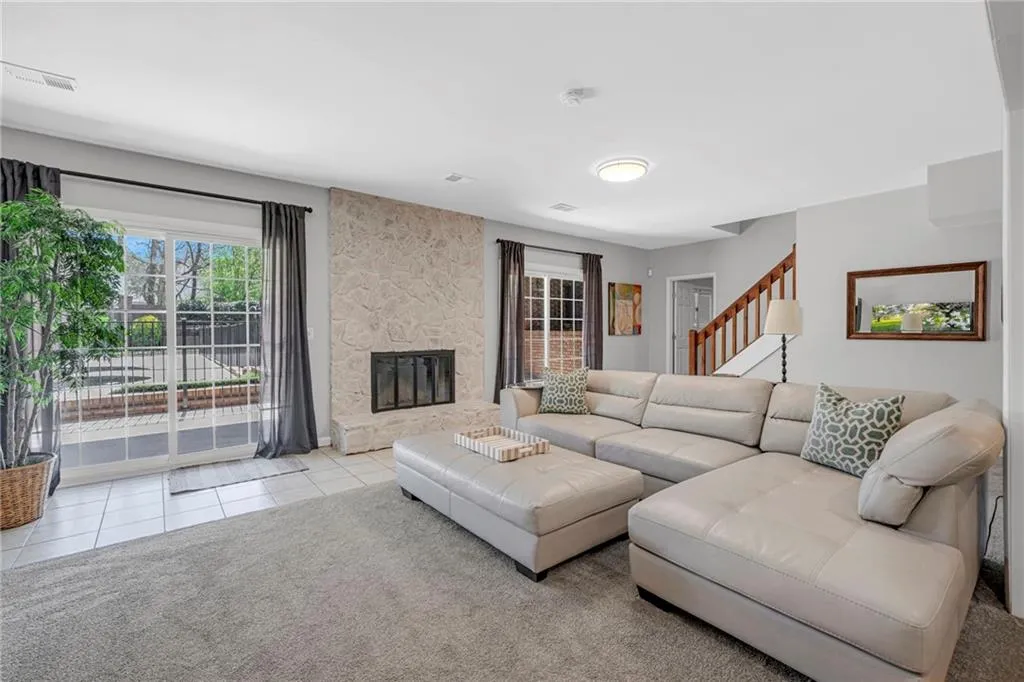 Carpeted living room with a stone fireplace