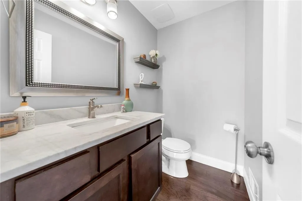 Bathroom with wood-type flooring, vanity, and toilet