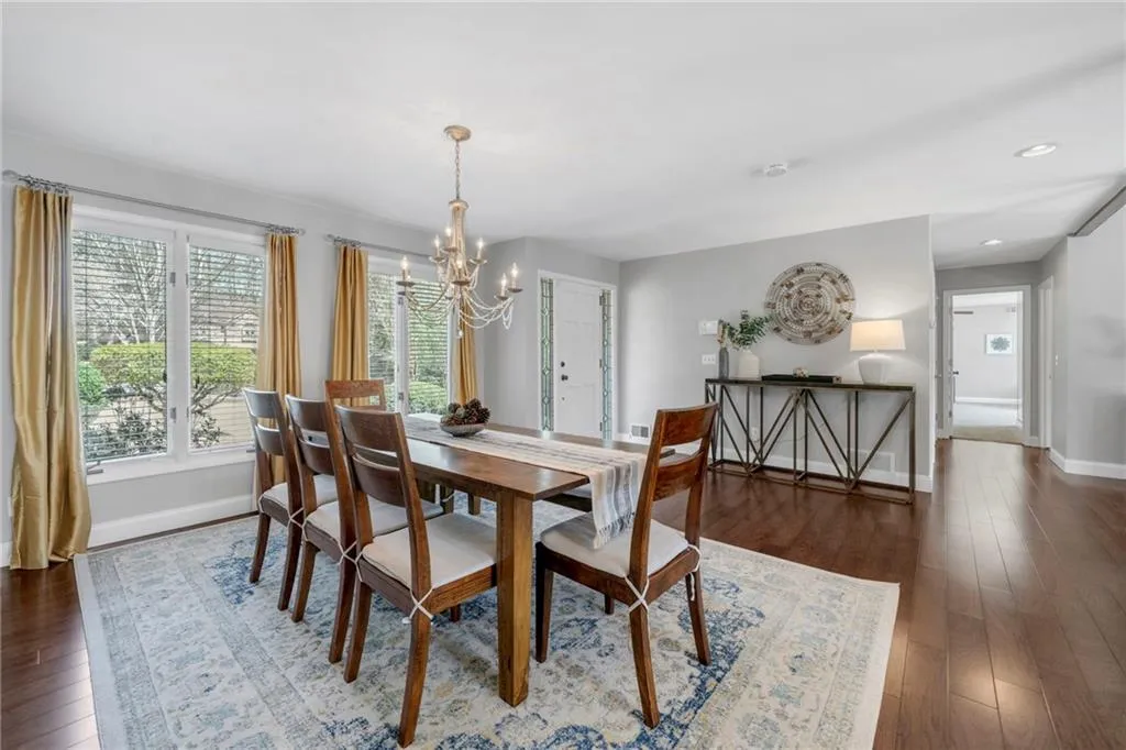 Dining space with an inviting chandelier and dark hardwood / wood-style floors