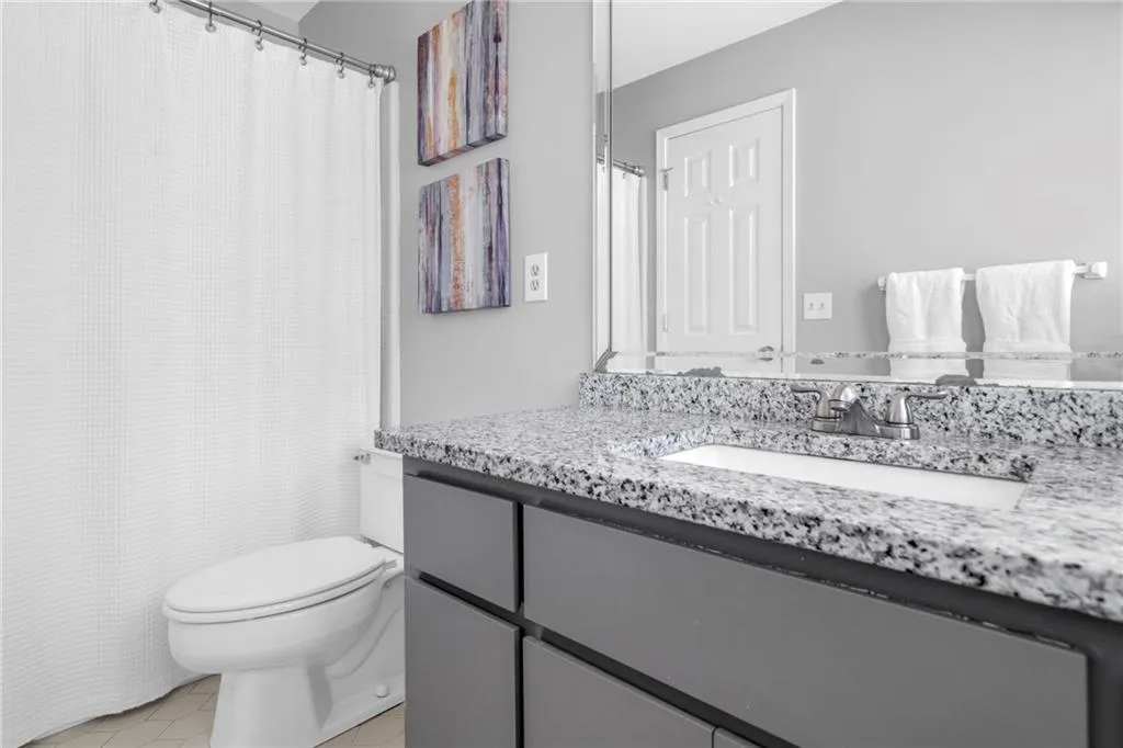 Bathroom featuring tile flooring, vanity, and toilet