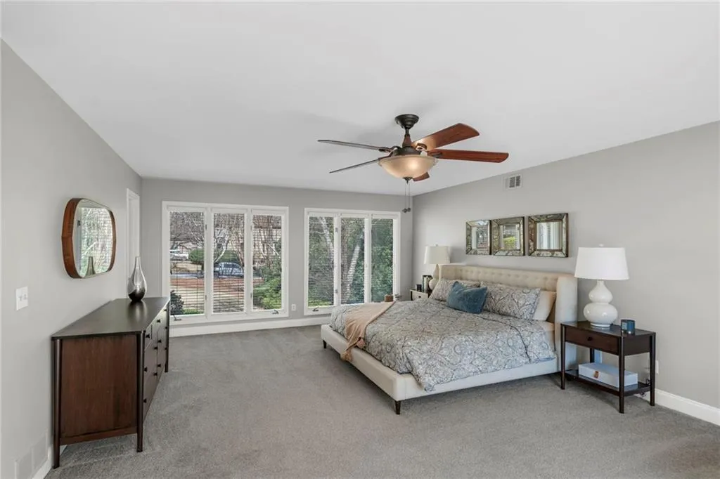 Carpeted bedroom featuring ceiling fan