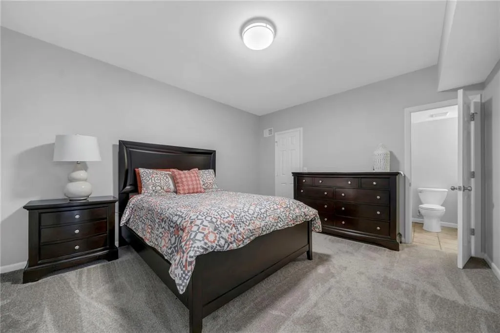 Carpeted bedroom with connected bathroom