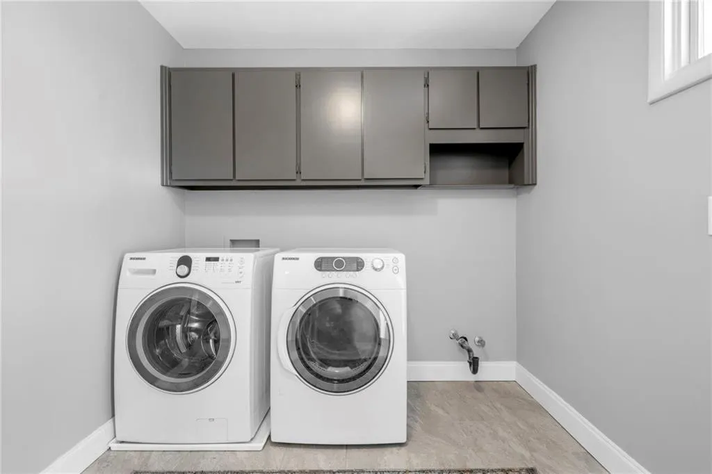 Laundry area featuring cabinets, light hardwood / wood-style flooring, separate washer and dryer, and hookup for a washing machine