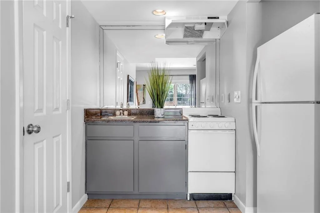 Kitchen featuring ventilation hood, gray cabinetry, white appliances, and light tile floors