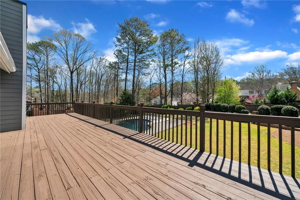 Wooden deck featuring a pool and a yard