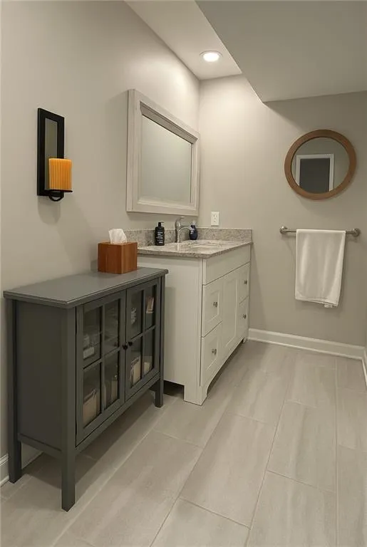 Bathroom with vanity, light tile patterned floors, and recessed lighting