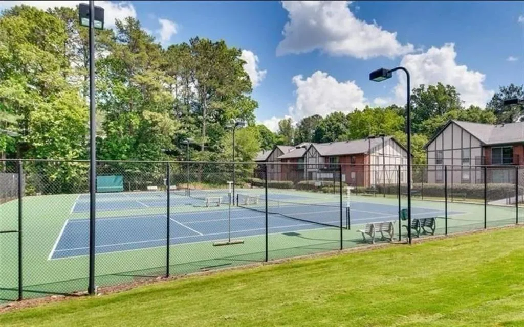 View of tennis court with a residential view